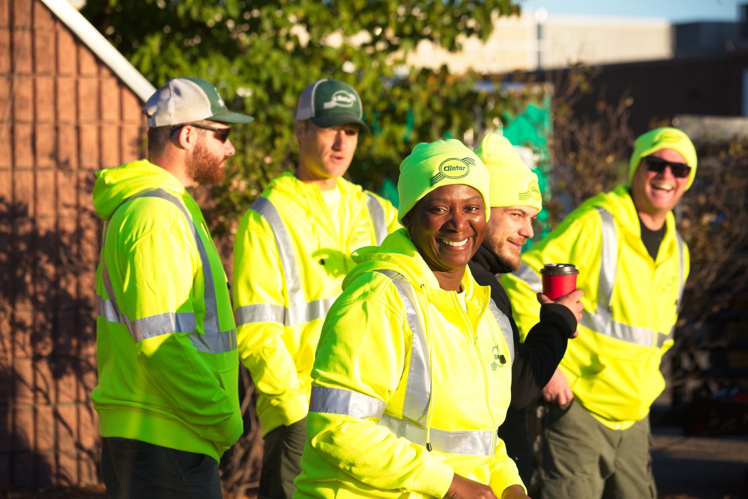 workers smiling and laughing in yellow jackets